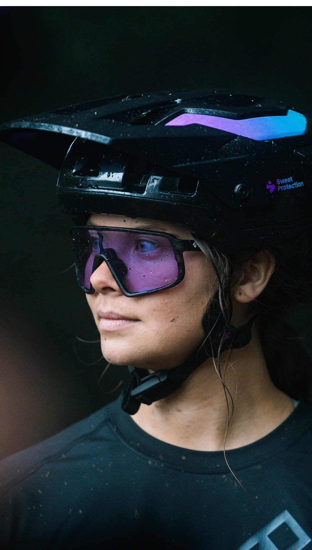Close-up picture of a girl wearing a mountain bike helmet and glasses, looking to the side.